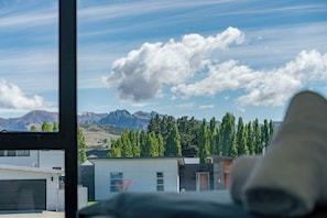 Un bĂątiment moderne offrant une vue sur les montagnes et les arbres.