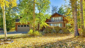 A two-story wooden house with a garage, surrounded by trees and a lawn covered with fallen leaves. - 14 Miles to Sun Valley: Updated Getaway! (Hailey)