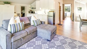 A modern living room with a grey sectional sofa, a patterned rug, and a kitchen in the background. - 14 Miles to Sun Valley: Updated Getaway! (Hailey)