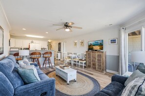 Un salon spacieux avec un canapé, une table basse et un coin repas.