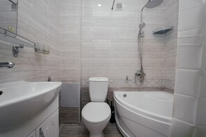 A modern bathroom with a white bathtub, a toilet, and a shower. - ZAAL (Samarkand)