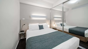 A hotel room with a large bed, bedside tables, a mirror, and a ceiling light. - Lakeside 1-Bed with A/C, Parking & Balcony (Greenway)