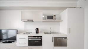 A modern kitchen with white cabinetry, a microwave, a stove, and an oven. - Lakeside 1-Bed with A/C, Parking & Balcony (Greenway)