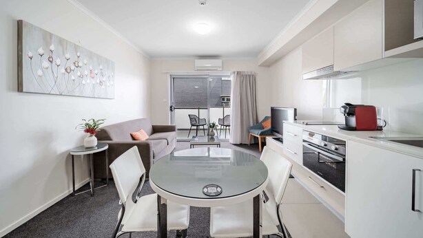 A compact living space with a dining area, kitchenette, and a balcony with a view. - Lakeside 1-Bed with A/C, Parking & Balcony (Greenway)