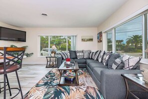 A modern living room with a sofa, coffee table, and a TV mounted on the wall.