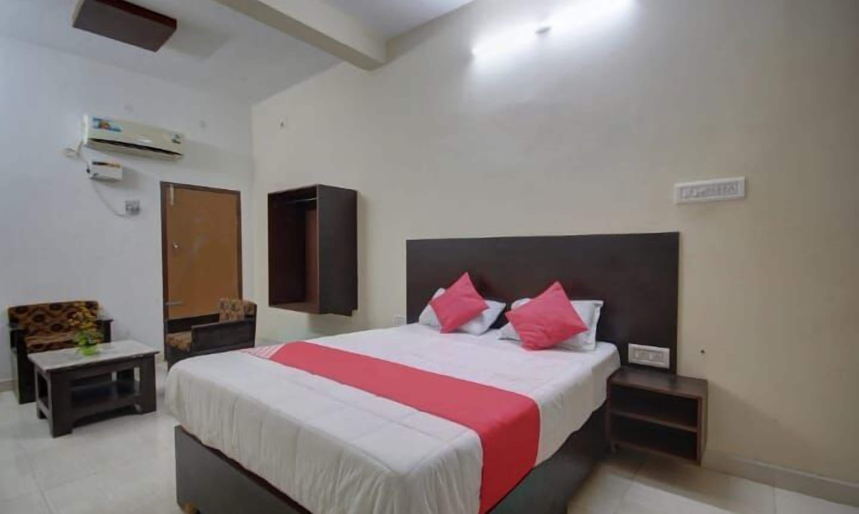 A bedroom with a bed, bedside tables, a wardrobe, and a wall-mounted air conditioner.