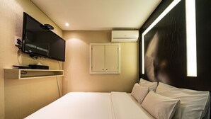 A hotel room with a bed, a flat-screen TV mounted on the wall, a wardrobe, and an air conditioning unit. - Hotel INN Seoul (Seoul)