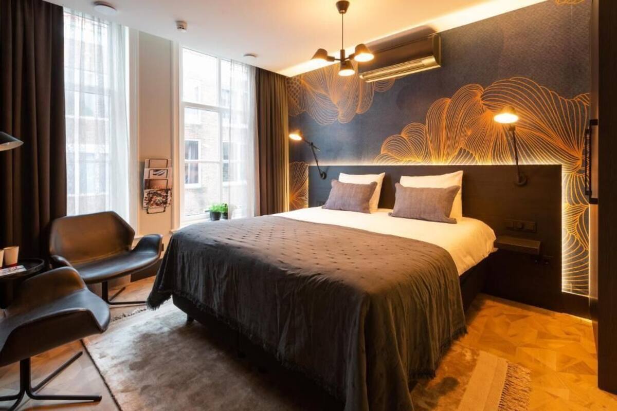 Ein modernes Schlafzimmer mit einem großen Bett, einem Schreibtisch und einem Sessel.