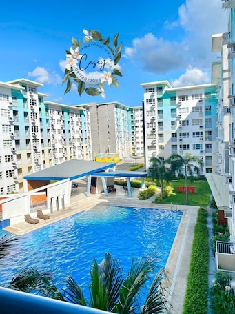A multi-story residential building with a swimming pool and outdoor seating area.