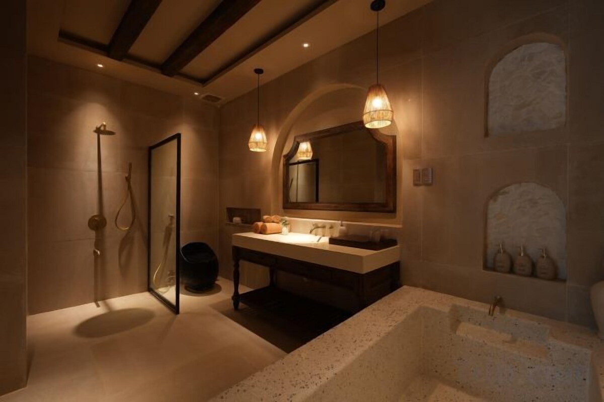 Une salle de bain avec une baignoire, une douche, un lavabo et un miroir.