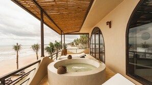 Un espace spa comprenant un jacuzzi, des chaises longues et une vue sur la plage.