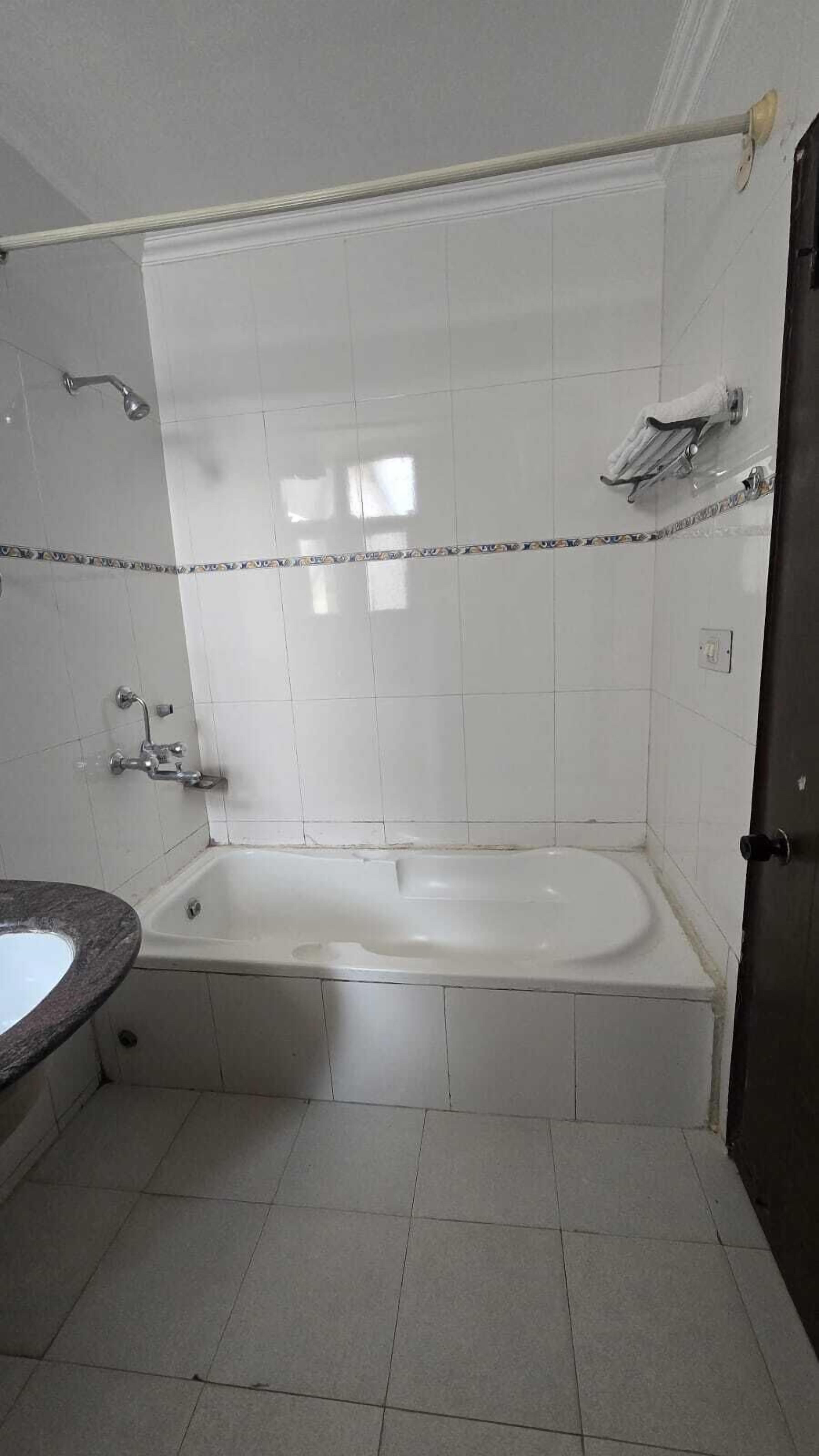 A bathroom with a bathtub, a shower, and a sink.