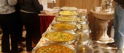 A buffet setup with various food items and a decorative fountain.