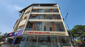 A multi-story building with a sign for "LIGHT HOUSE SUITES" indicating rooms and conference hall availability. - Light House Suites Hubballi (Hubli)