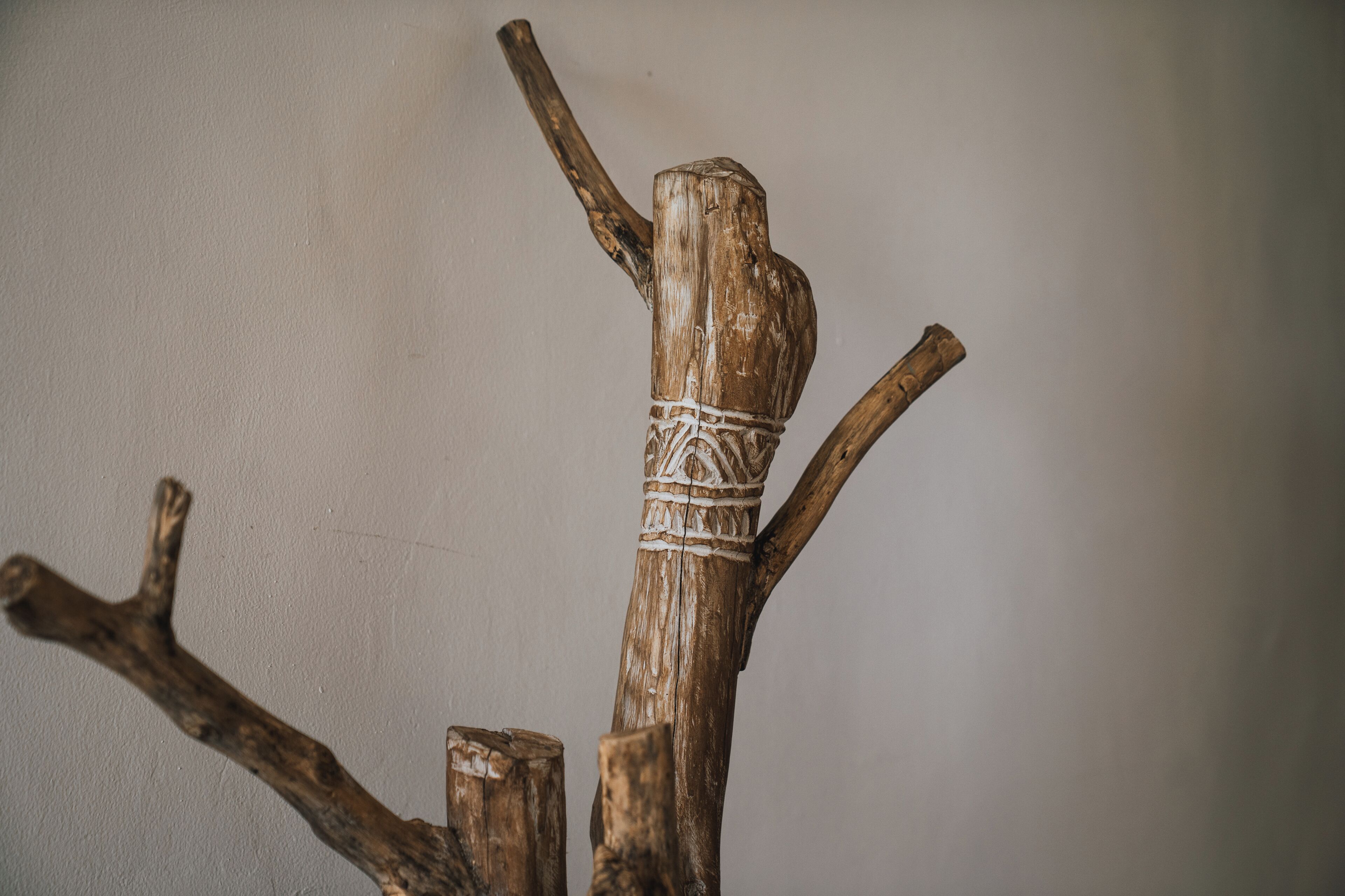 A wooden structure with a carved top and a rope tied around it.