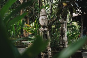 Una estatua de piedra en un entorno verde y exuberante.