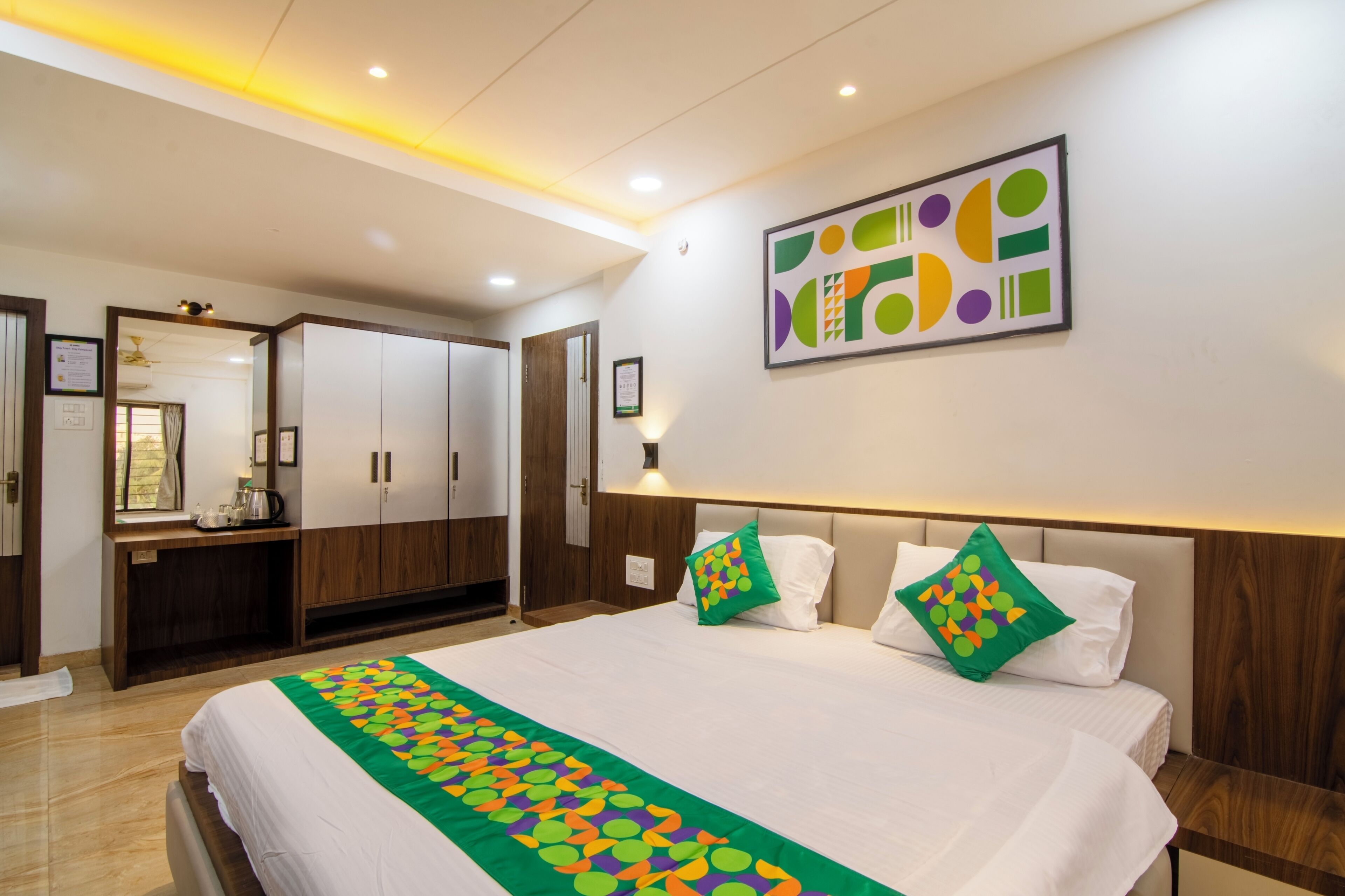 Habitación de hotel con una cama grande, un escritorio y un armario.