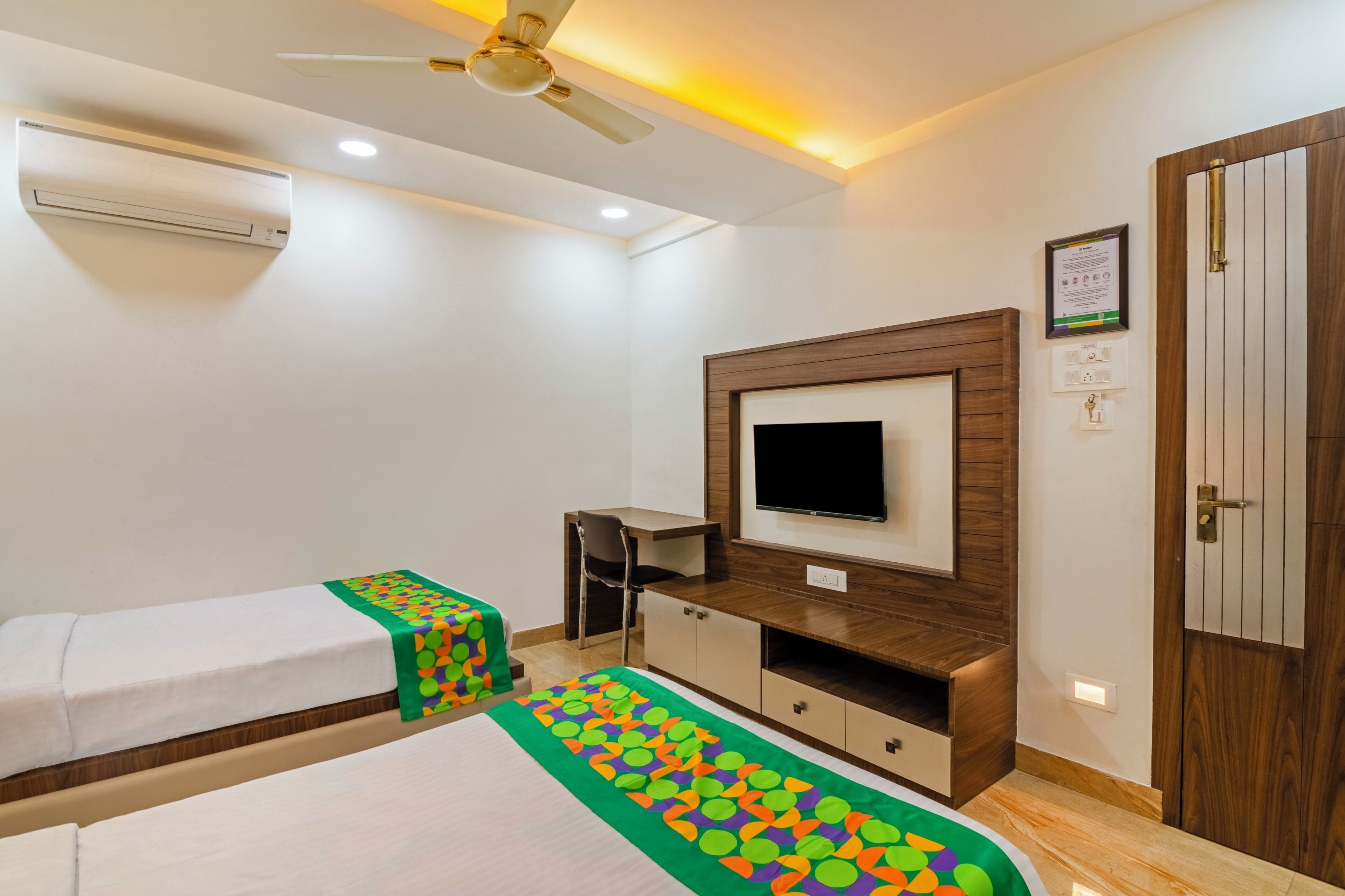 A hotel room with a bed, a desk, a TV, and a wardrobe.