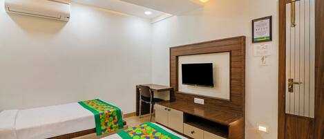 A hotel room with a bed, a desk, a TV, and a wardrobe.