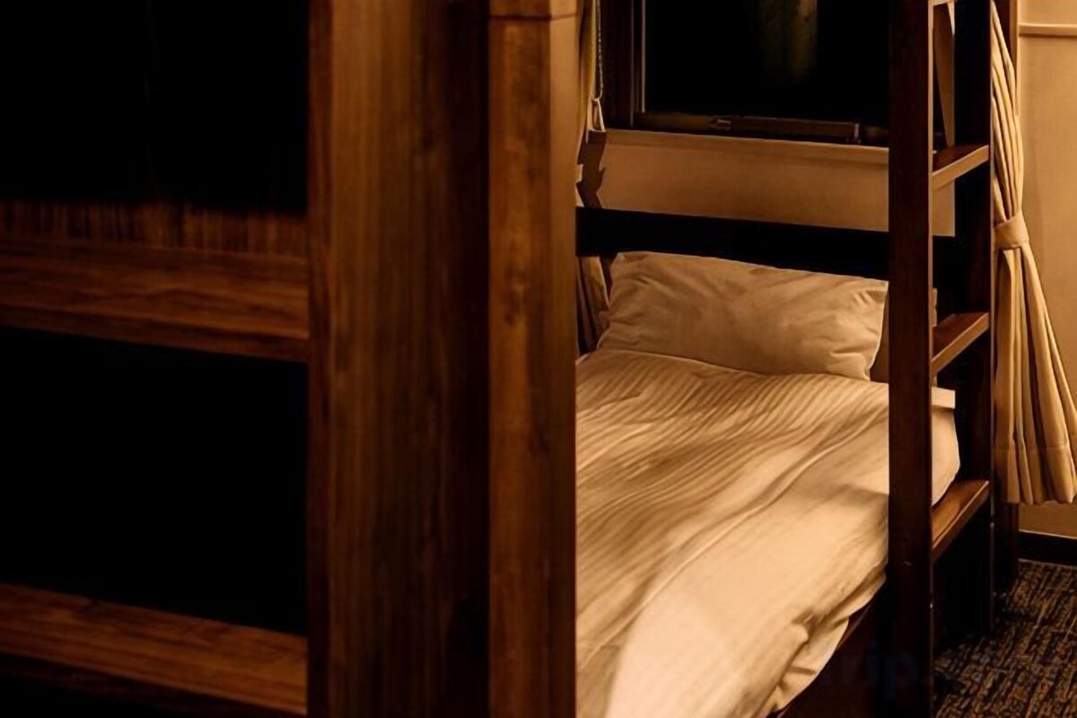 Un letto a castello con struttura in legno e biancheria bianca.