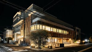 Un bâtiment moderne doté d’une façade incurvée, de grandes fenêtres et d’un espace de stationnement pour vélos.