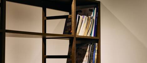 A wooden bookshelf with multiple compartments, some filled with books and others empty.