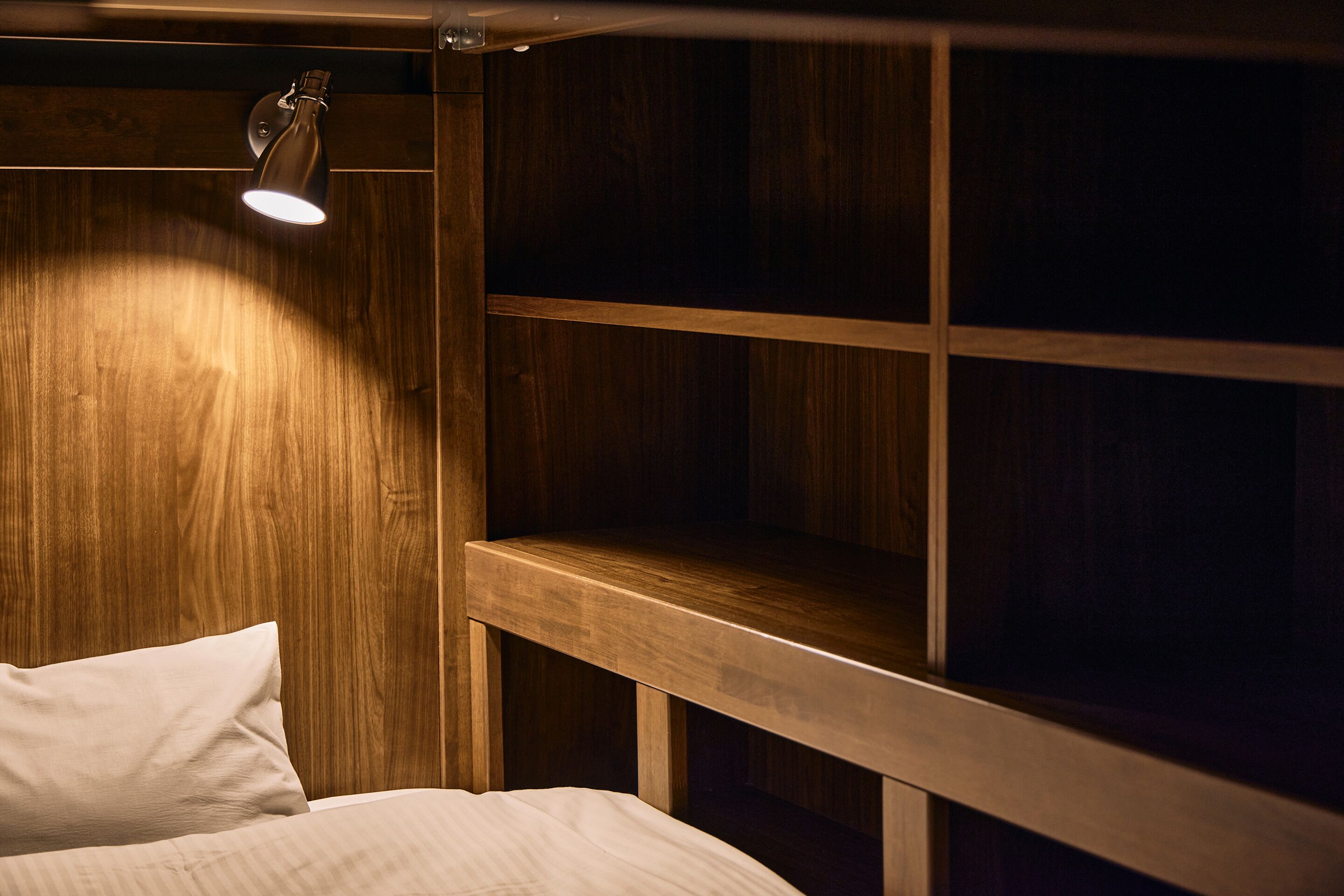 Una cama litera de madera con cabecera y mesita de noche.