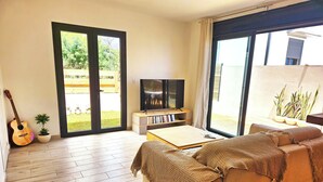 A modern living room with a sofa, a coffee table, a TV, and a guitar. - Villa of the Three Monkeys. Between the beach and the mountains. (Saint-Pierre)