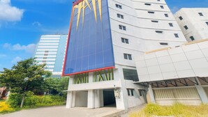 Een modern gebouw met een golvende gevel, grote ramen en een opvallend verticaal element.