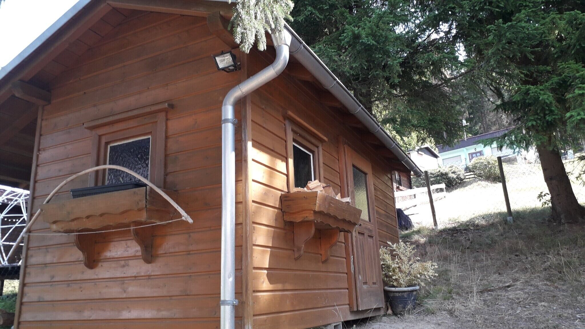 A wooden cabin with a window, a door, and a small porch area.
