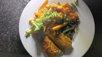 Un plato con pollo a la parrilla, zanahorias y brócoli.