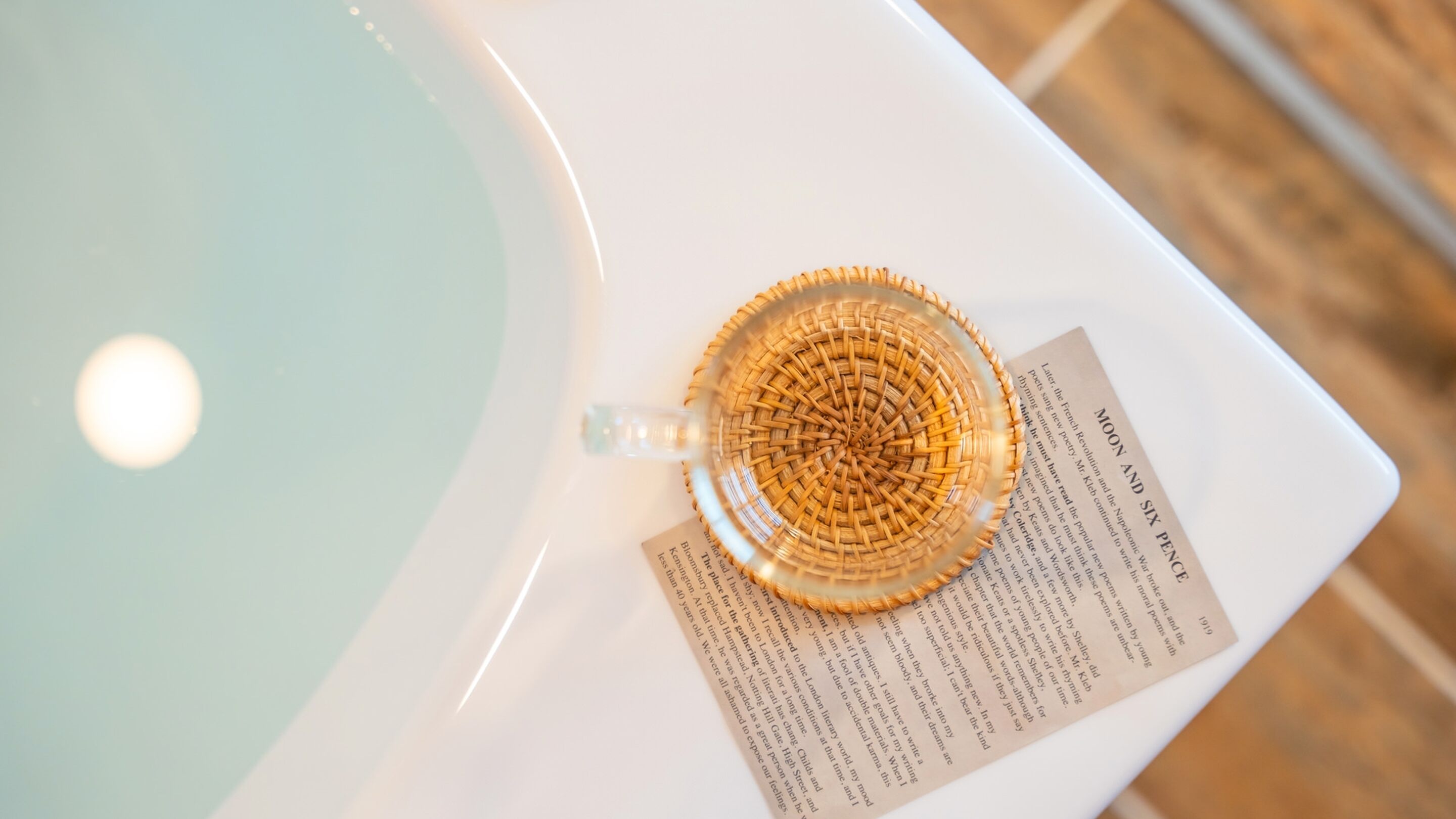 Un évier blanc avec un récipient en verre transparent et un distributeur de serviettes en papier.
