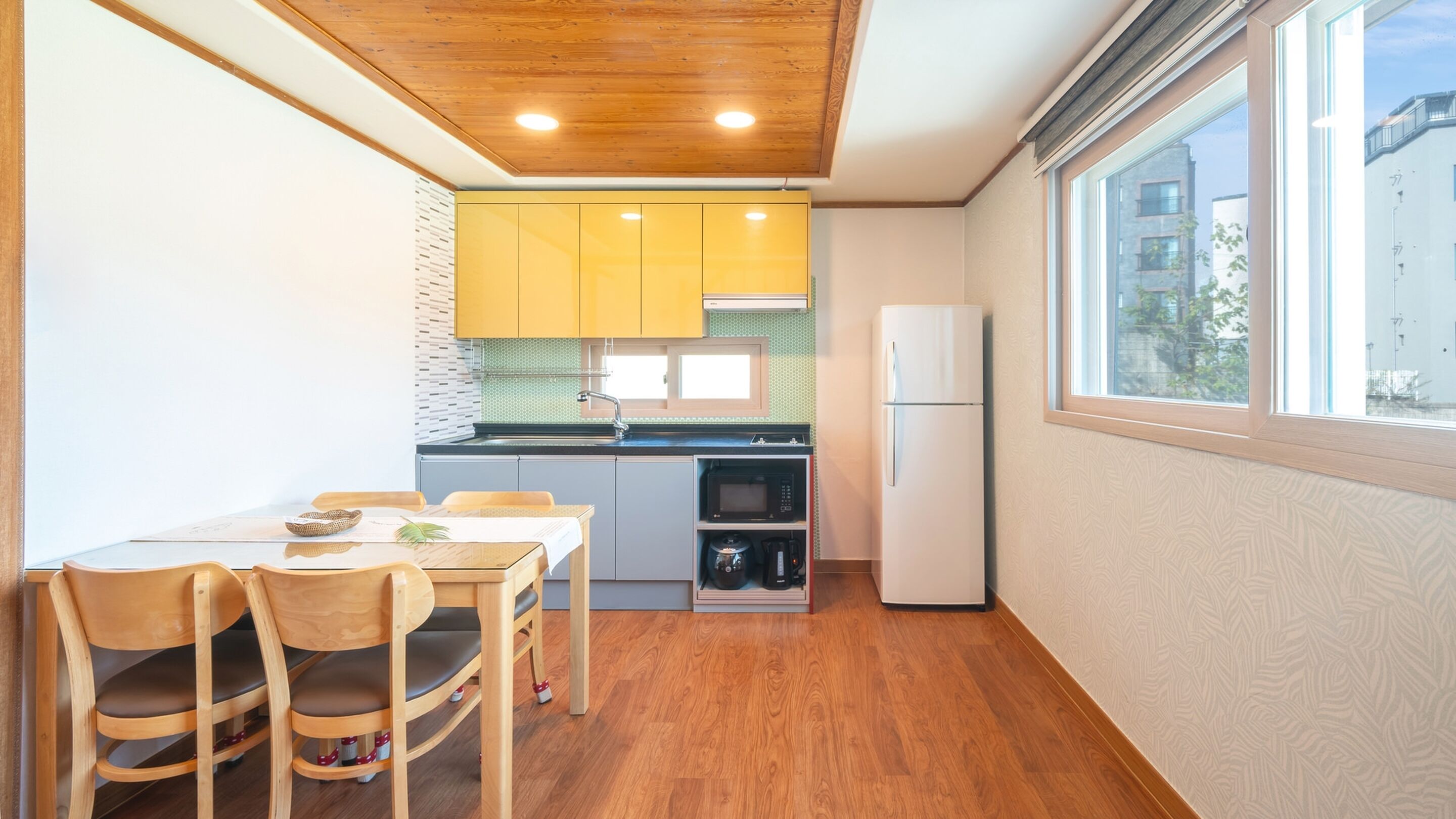 A compact kitchen with wooden cabinets, a built-in microwave, and a refrigerator.