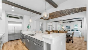 Una cocina moderna con una isla central, electrodomésticos de acero inoxidable y suelo de madera.