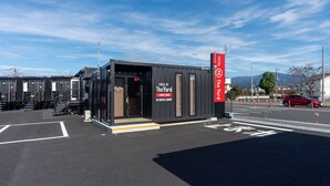 Un hotel moderno con recepción, un carril bici y una zona de estacionamiento.