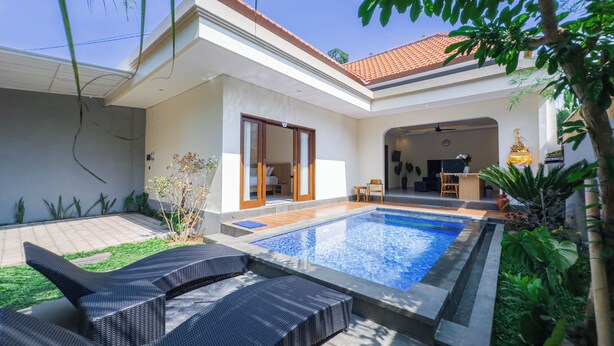 A modern house with a swimming pool, outdoor seating, and a well-maintained garden. - Gold Fish House Ubud (Ubud)