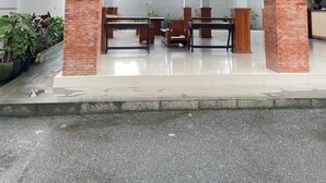 Der Eingang des GIRI KUSUMA HOTEL mit einer Ziegel-Fassade, einem Innenbereich mit Sitzgelegenheiten und Blick auf die umliegende Bepflanzung.