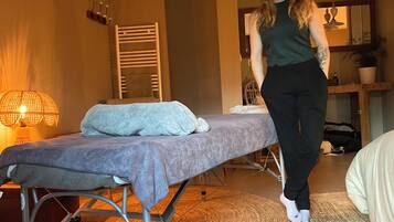 Relax in a serene space with a massage table and setting.
