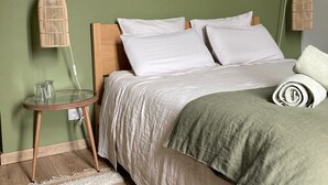 A bedroom with a bed, a small round table, and two hanging light fixtures. - Ô Bord de Loire (Denée)