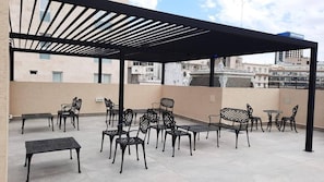 A rooftop terrace with outdoor seating, including tables and chairs, and a pergola structure. - Modern & Cozy Studio in San Telmo With Pool and Balcony (Buenos Aires)
