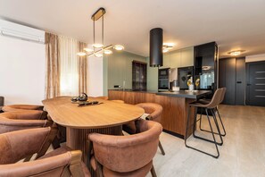 Una cocina moderna con una isla central, mesa de comedor de madera y sillas a juego.