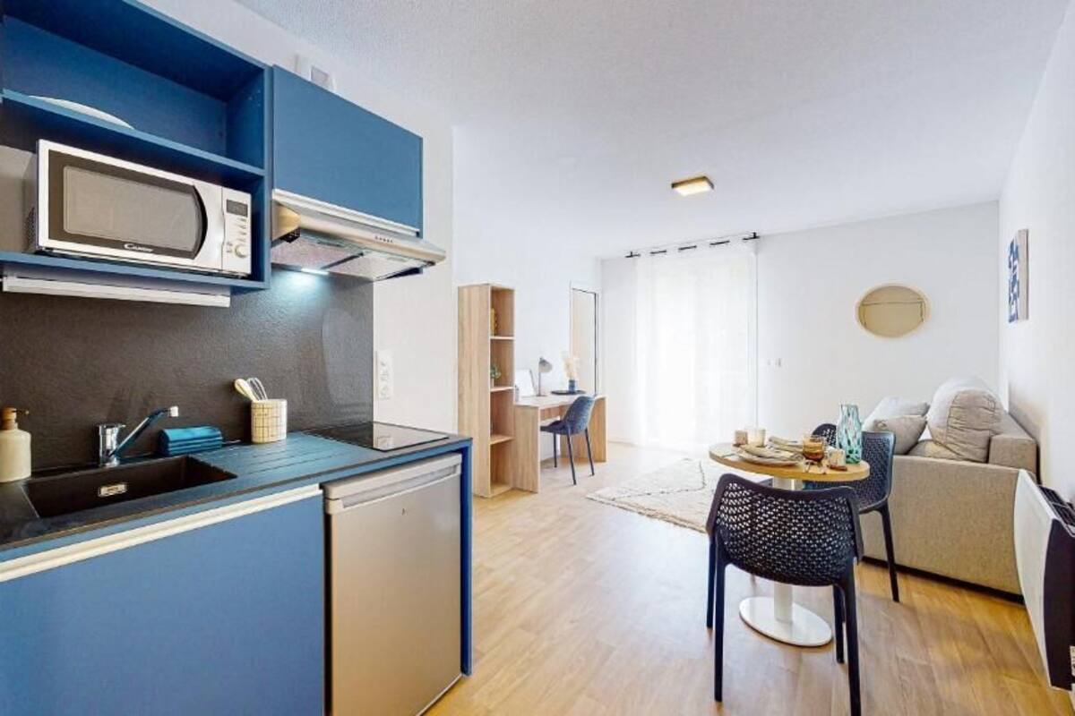 Un apartamento pequeño con kitchenette, comedor y sala de estar.