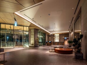 A modern lobby with a reception desk, seating area, and large glass doors leading outside. - SAPPORO HOTEL by GRANBELL (Sapporo)