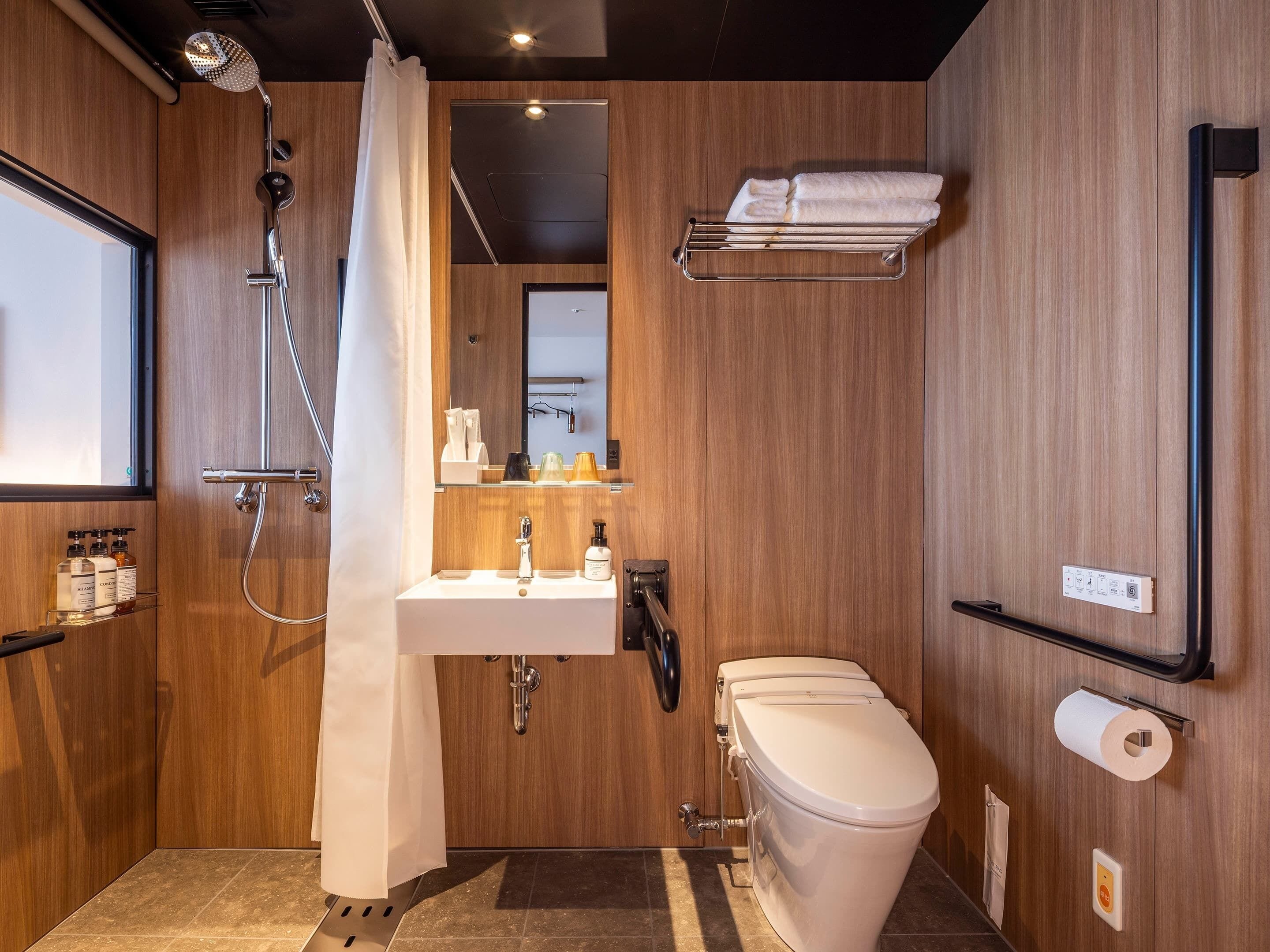 Un baño moderno con ducha, inodoro, lavamanos y toallero.