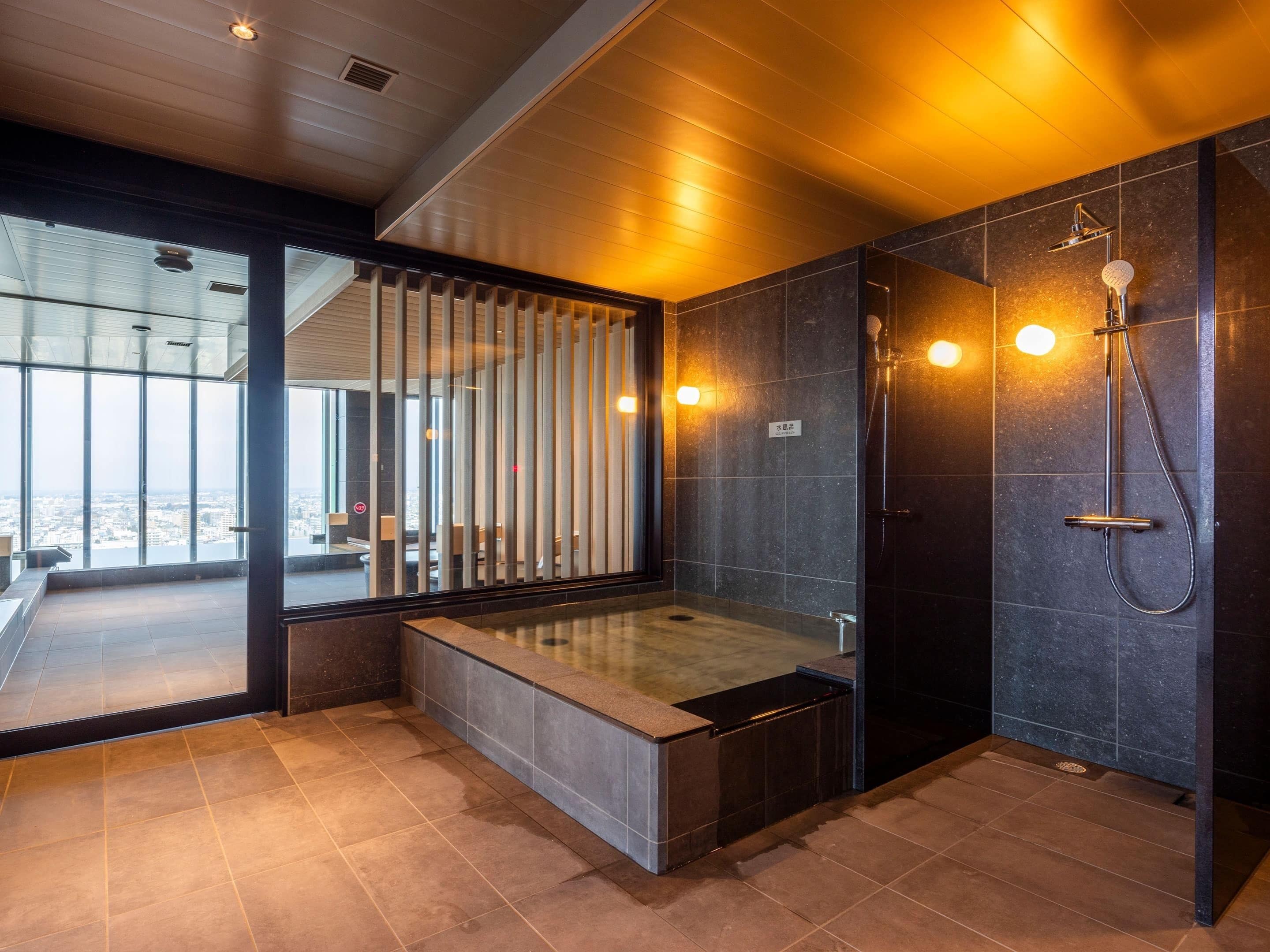 A modern bathroom with a large window, a bathtub, and a shower area.