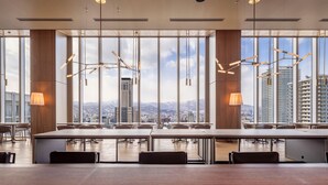 Una sala de conferencias moderna con ventanas amplias, una mesa larga e iluminación minimalista.