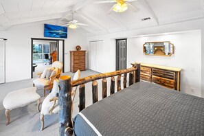 A bedroom with a bed, a wooden headboard, a dresser, a chair, and a painting on the wall. - Lakefront Splendor:Spectacular Lakefront Property w/Private Dock! Pool Table + Foosball Table! Spacious Outdoor Deck! Patio & Yard w/Firepit! (Big Bear Lake)