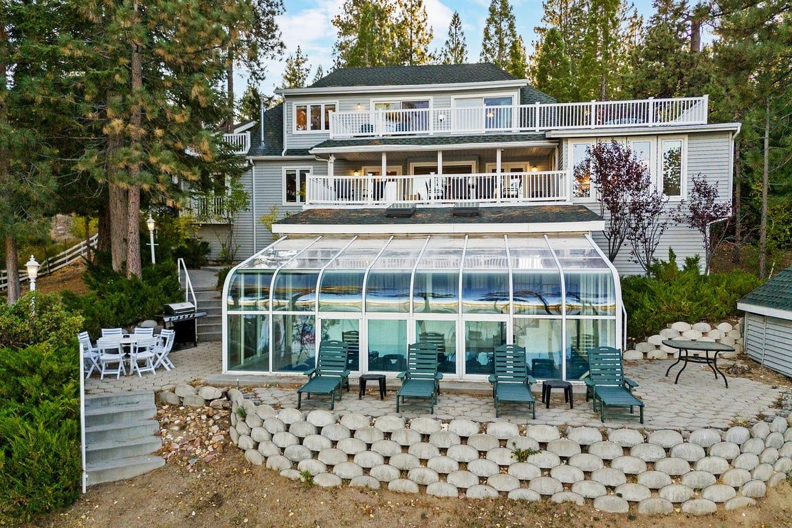 A two-story house with a glass-enclosed patio area.