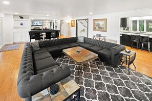 A modern living room with a sectional sofa, a coffee table, and a patterned rug.