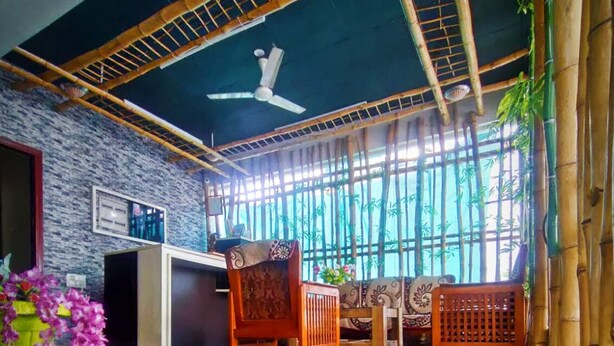 A room with a bamboo ceiling, a reception desk, and a seating area with traditional chairs. - Shavin Residency Wardha Maharashtra (Wardha)